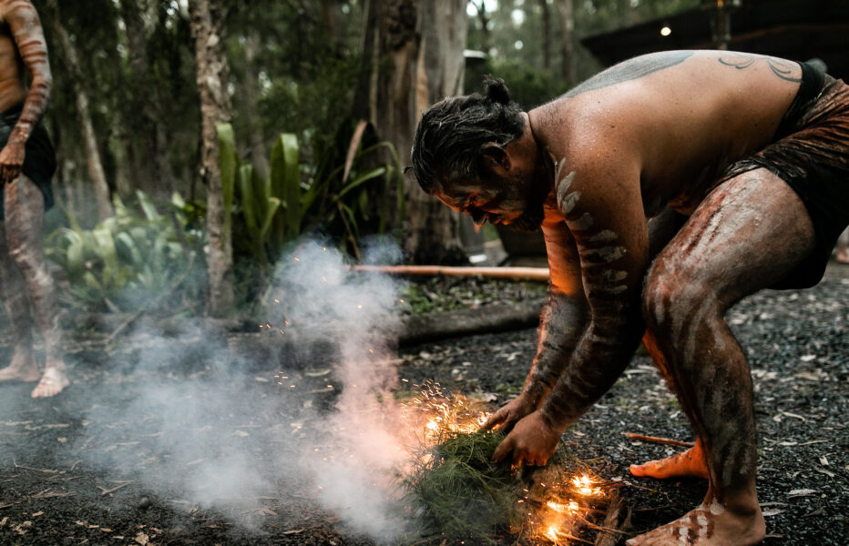 Indigenous Australian creating fire and smoke for a ceremony